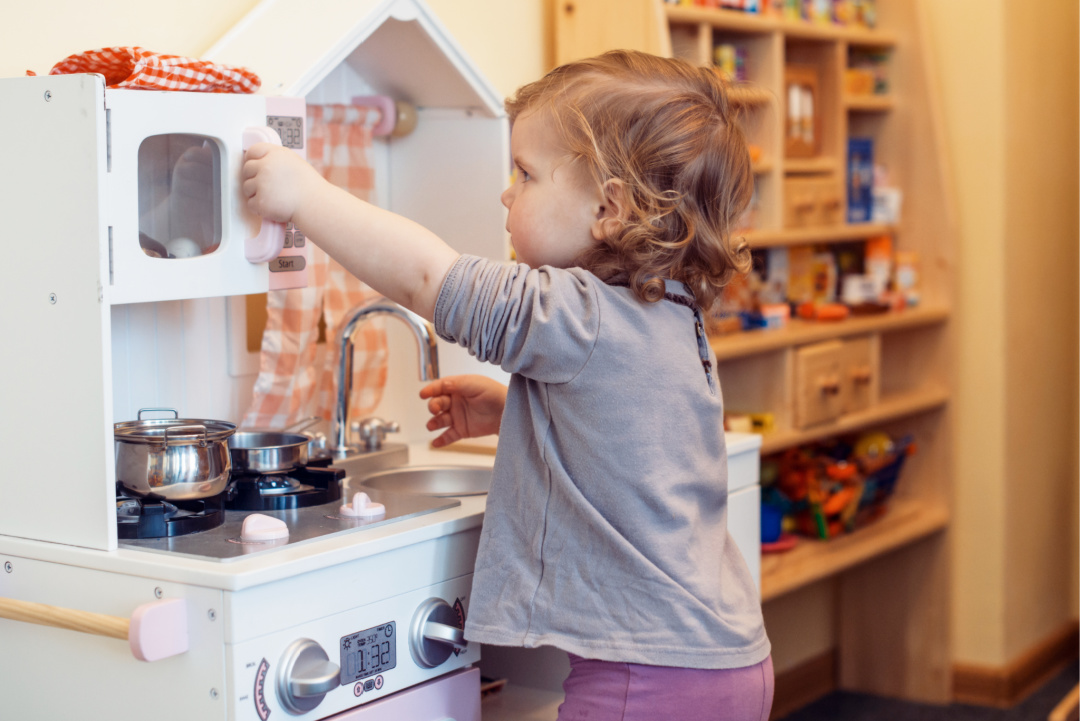 Toddler assembling a play kitchen